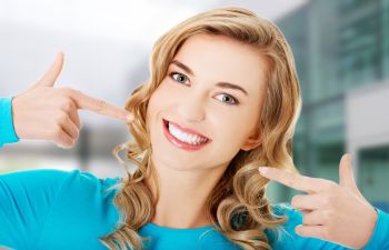 Woman Pointing at Her White Smile